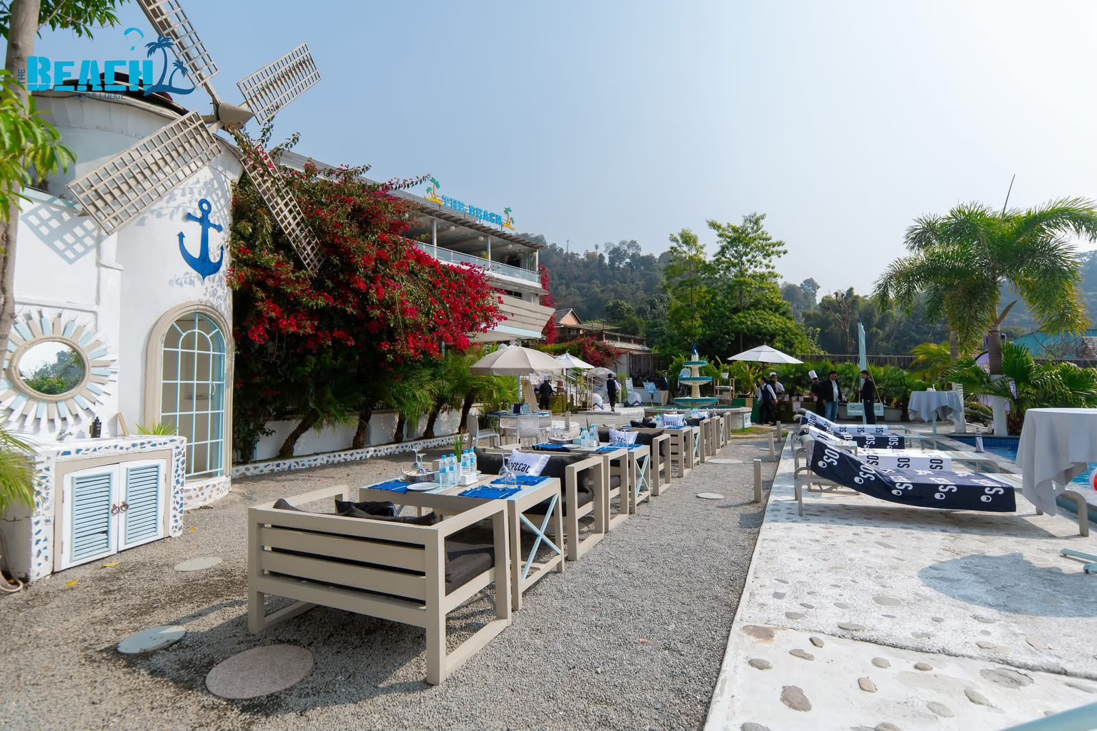 Bright white lounge seats and tables by the pool at The Beach